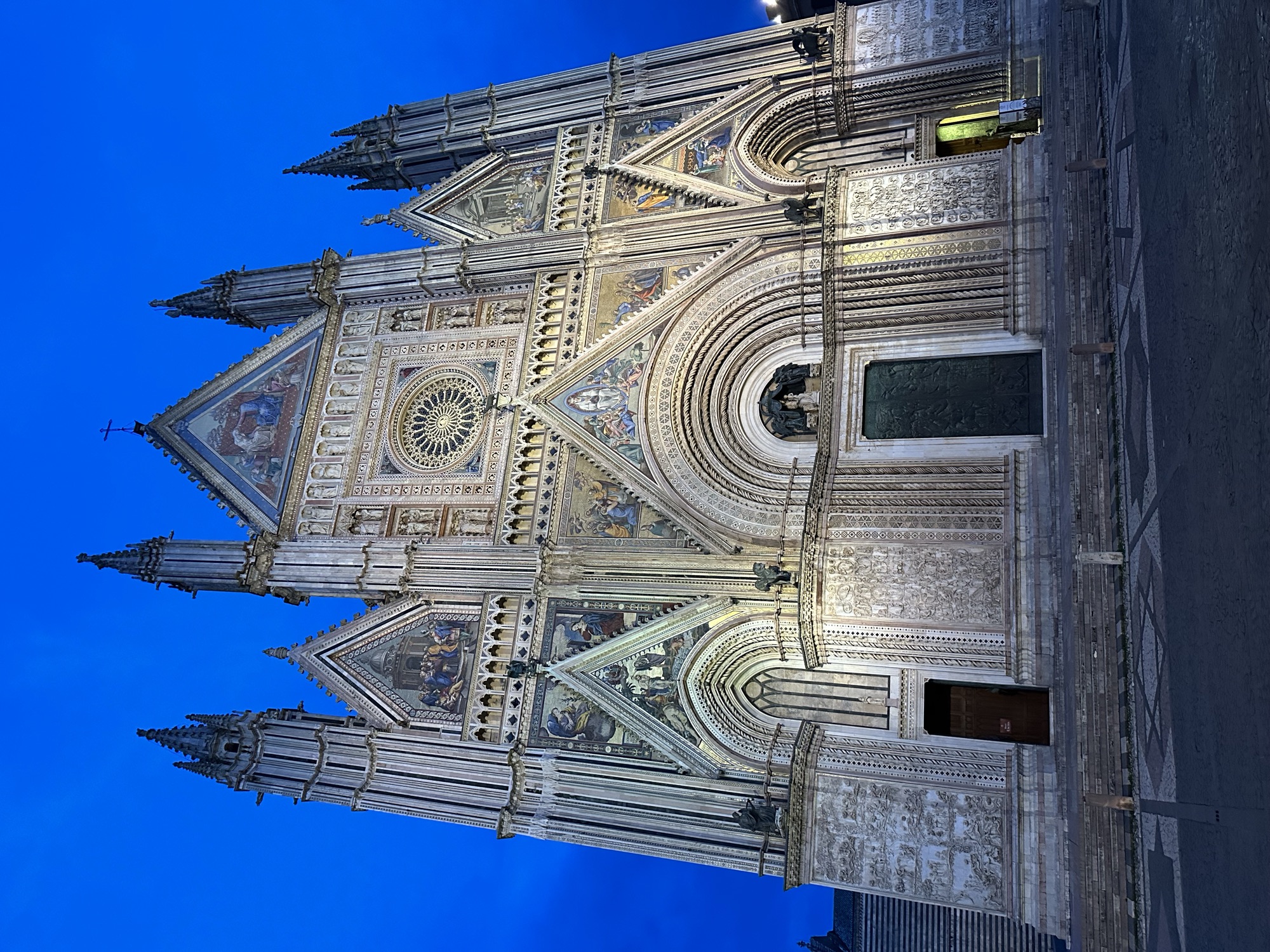 Die beleuchtete Fassade des Doms von Orvieto in der Abenddämmerung